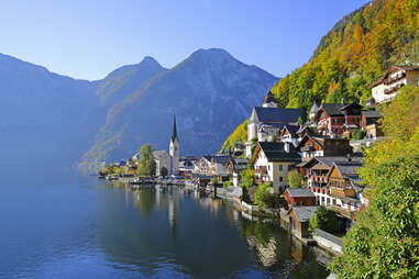 halstatt austria, cliffside village, with mountains in the background