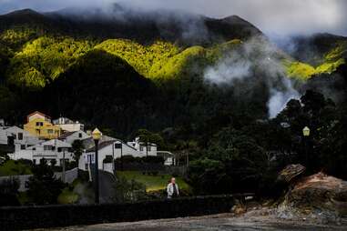 man standing near geysers, in furnas, azores, part of portugal