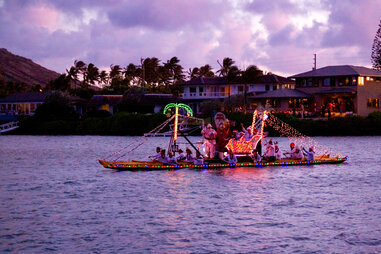 christmas themed boat, floating past a tropical landscape, in hawaii