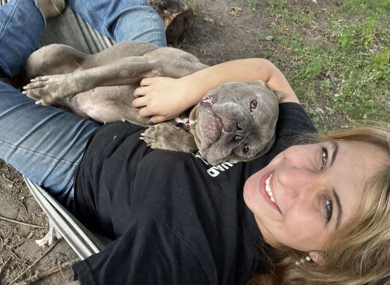 dog cuddling woman