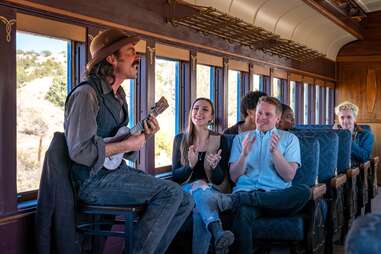 man playing ukulele on a train