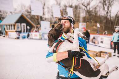 man holding dog in snow