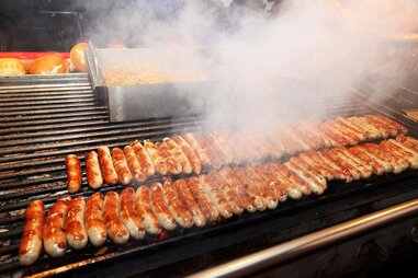 line of german sausages on a grill