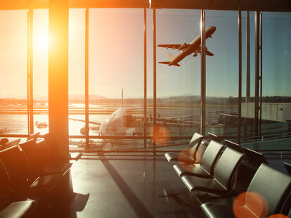 Airport interior airplane takeoff seen through terminal window