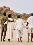 couple walking with parents on beach