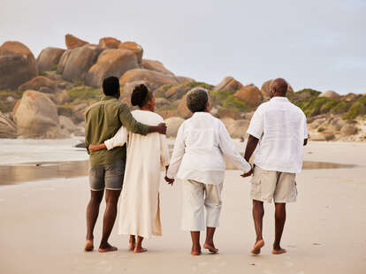 couple walking with parents on beach