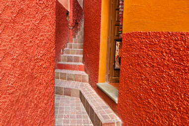 the alley of the kiss in guanajuato, mexico, is red and orange and narrow