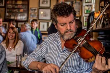 man playing fiddle in a dublin pub