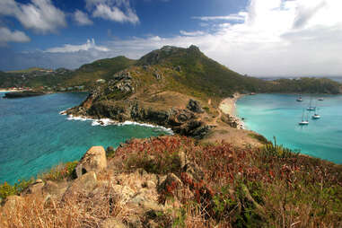 a foot trail in st. barts that leads to a blue bay for swimming