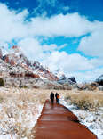 hikers ascending a snowy trail at zion national park 