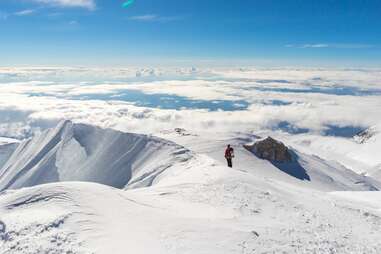 climber enjoying panorama view on top of mt denali