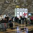 Travellers queue to check-in for their flight departure at Singapore Changi airport