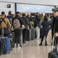 Travelers wait to check in at the American Airlines ticket counter at San Francisco International Airport