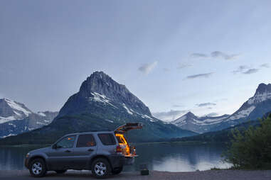 an SUV parked below mt. grinnell in montana during the winter