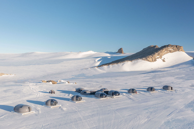 Snow globe shape glamping pods in the frozen tundra of Antarctica.