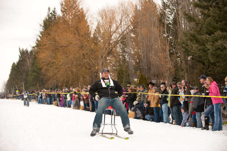 guy on barstool mounted on skis 
