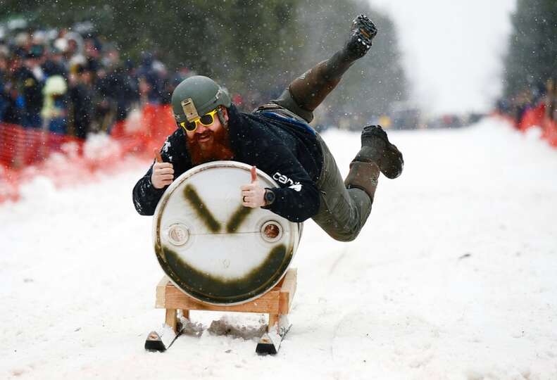 A man riding a keg down a slope