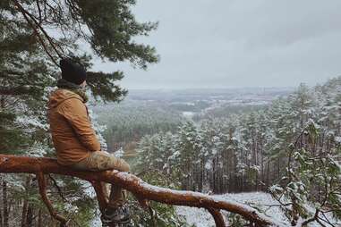 hiker sitting on a tree in the snow