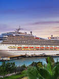 Cruise ship Carnival Conquest docked at Port Willemstad in Curaçao during sunset. 