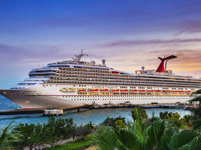 Cruise ship Carnival Conquest docked at Port Willemstad in Curaçao during sunset.