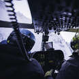 interior shot of a helicopter headed toward a mountain valley in the chugach range in alaska