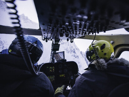 interior shot of a helicopter headed toward a mountain valley in the chugach range in alaska