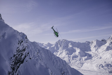 a helicopter nosediving into an alaskan mountain valley
