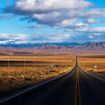 open stretch of us highway 50 in nevada with no cars ahead and blue skies above