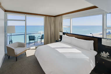 a large bed near windows overlooking the ocean