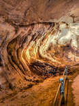 a lit-up underground passage with a footpath in gunung mulu national park in malaysian borneo