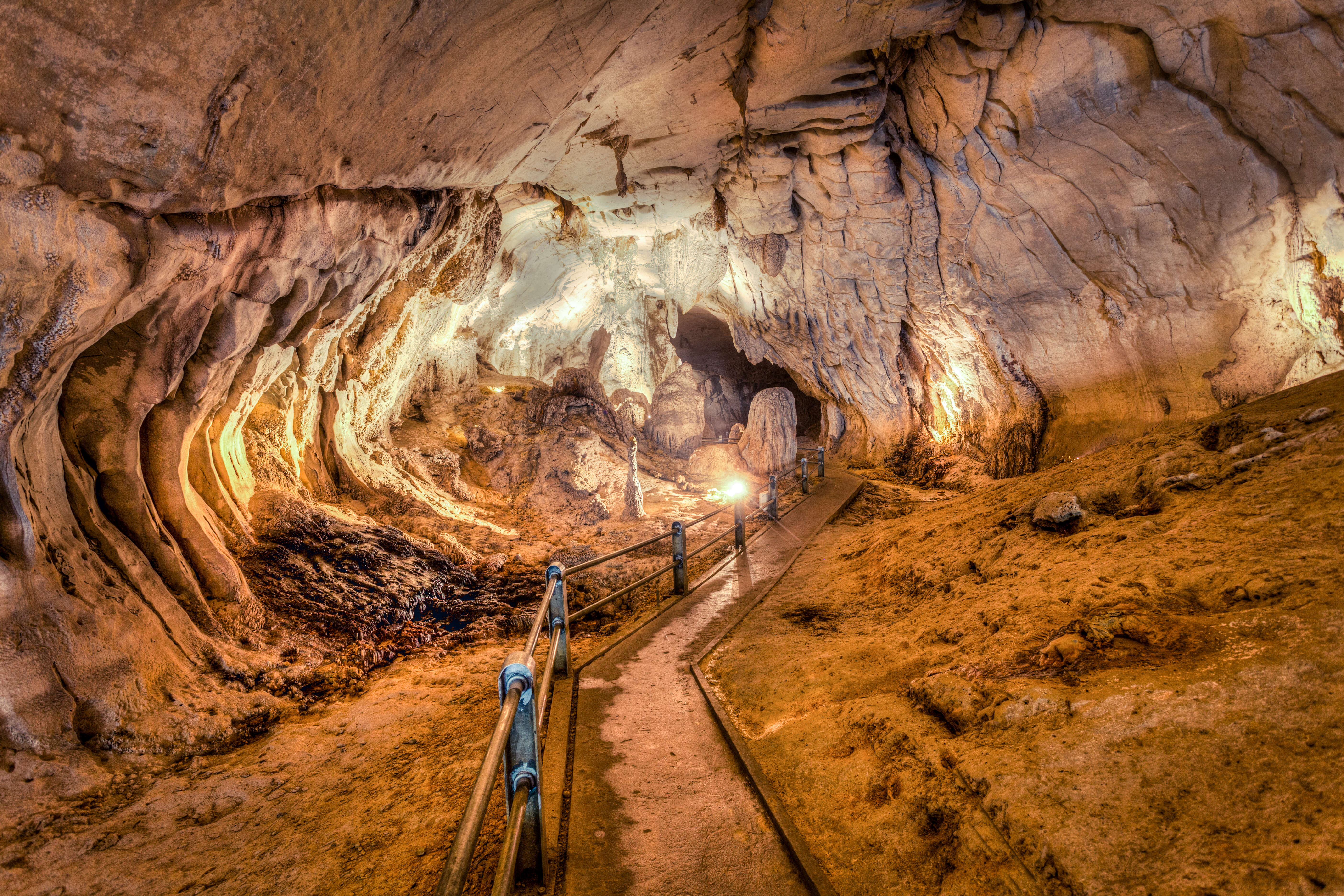 a lit-up underground passage with a footpath in gunung mulu national park in malaysian borneo