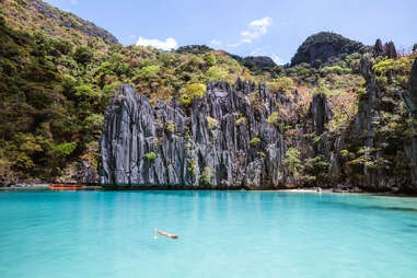 woman floating in idyllic lagoon, el nido