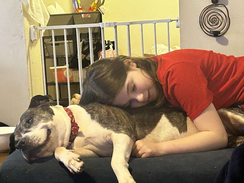 dog cuddling with a child