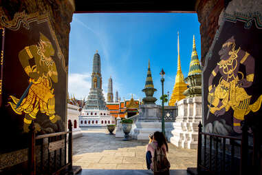 tourist taking a photo at temple of the emerald buddha in bangkok