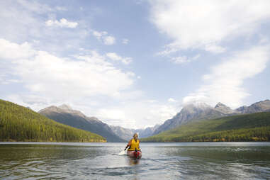 woman kayaking on a lake in glacier national park