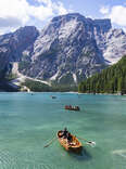 people canoeing on lake braies, dolomite, italy