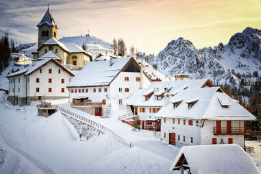 snow-topped cottages in mount lussari village, tarvisio, italy