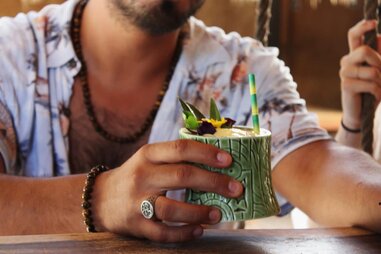 man holding tropical cocktail