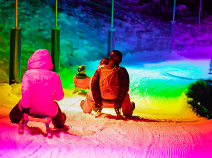 people sledding down mario kart-inspired light ride in switzerland