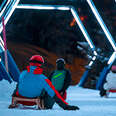 sledders racing down the light ride course in the swiss alps