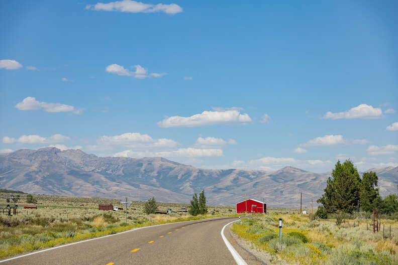 a road leading to a red barn in Nevada
