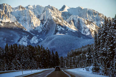 a car driving down icefields parkway cutting through banff national park