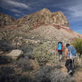 Rear view of friends hiking on mountain against cloudy sky USA, Nevada, Red Rock Canyon
