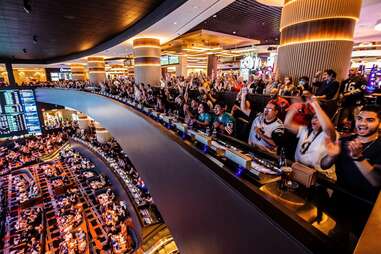 sports fans cheering in a casino stadium bar