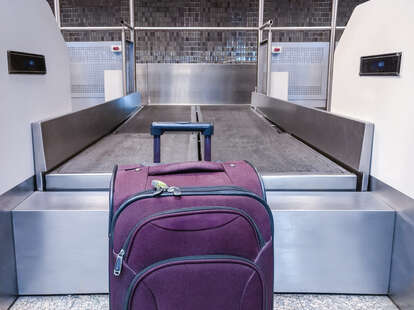 Suitcase in front of an airport mat waiting to be dispatched