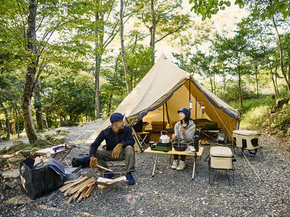 Couple enjoys camping at a campground in the woods.