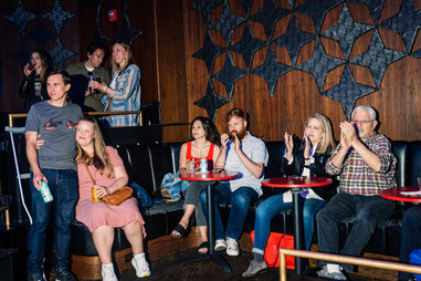 music fans sit at a concert venue