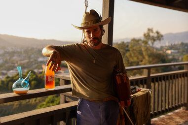 paris hunter paul posing with natural wine on a balcony in LA