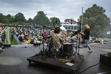a view from the stage behind a drummer and guitar player