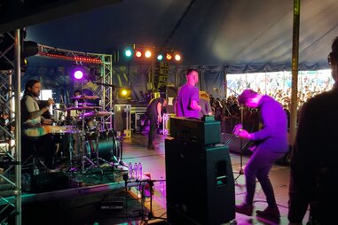 a band on a stage viewed from the back left